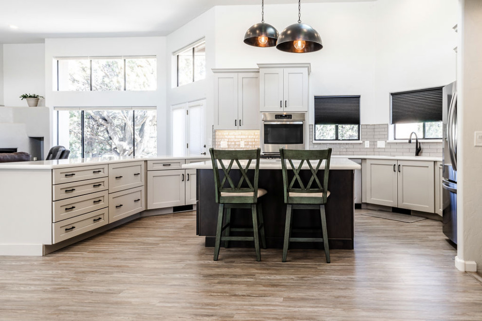 Inspiration for a large transitional u-shaped eat-in kitchen in Other with an undermount sink, shaker cabinets, grey cabinets, quartzite benchtops, green splashback, subway tile splashback, stainless steel appliances, vinyl floors, with island, grey floor and white benchtop.