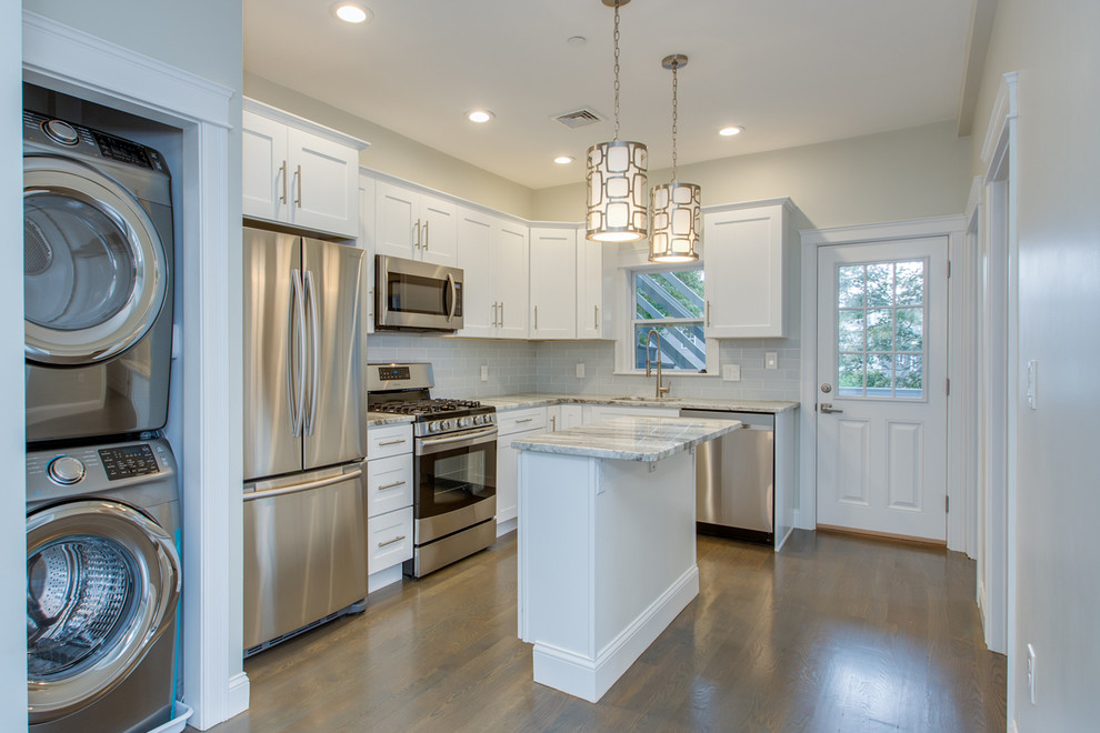 Mid-sized transitional l-shaped dark wood floor and brown floor enclosed kitchen photo in Boston with an undermount sink, shaker cabinets, white cabinets, marble countertops, gray backsplash, subway tile backsplash, stainless steel appliances, an island and white countertops