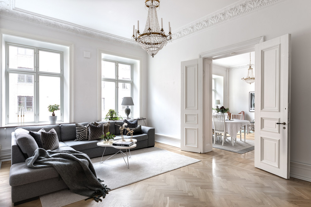 Photo of a transitional enclosed living room in Gothenburg with white walls, light hardwood floors and beige floor.