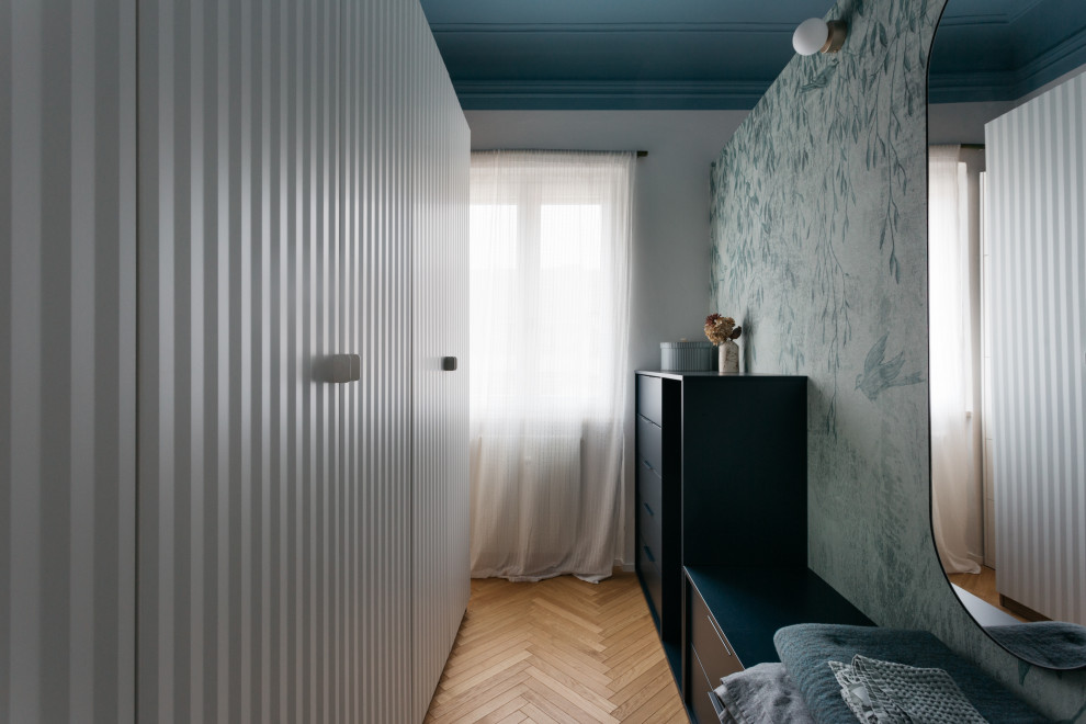 Aménagement d'un dressing room scandinave neutre avec des portes de placard blanches, parquet clair et un sol marron.