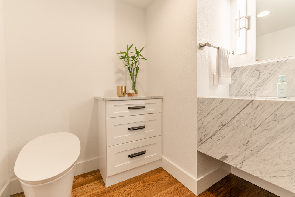 Idéer för ett stort modernt grå toalett, med skåp i shakerstil, vita skåp, en bidé, vita väggar, ljust trägolv, ett undermonterad handfat, marmorbänkskiva och brunt golv
