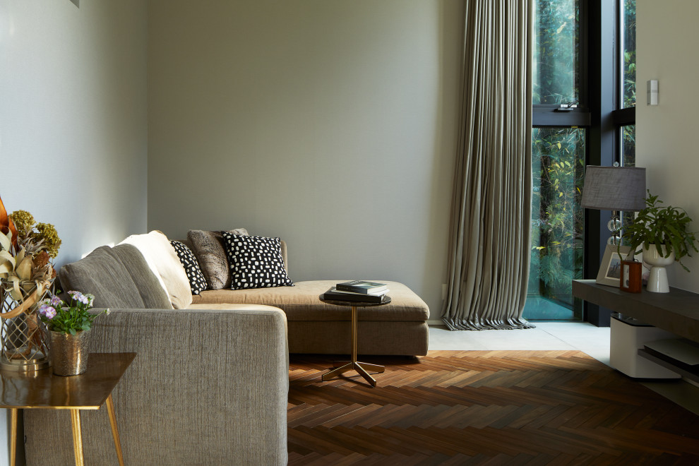 Modernes Wohnzimmer mit beiger Wandfarbe und grauem Boden in Sonstige