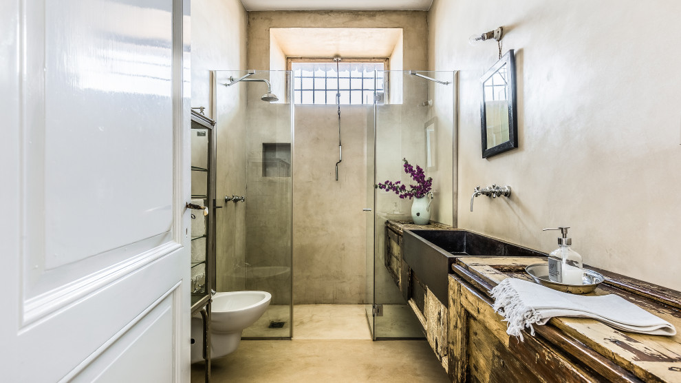 Mediterranean bathroom in Other with shaker cabinets, distressed cabinets, an alcove shower, gray tile, grey walls, wood benchtops, grey floor, a hinged shower door, a single vanity and a floating vanity.