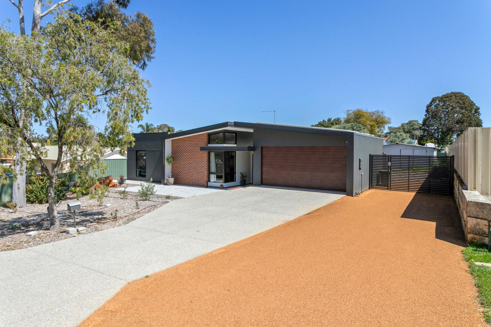 Photo of a mid-sized industrial one-storey black house exterior in Perth with a shed roof, a metal roof and a black roof.