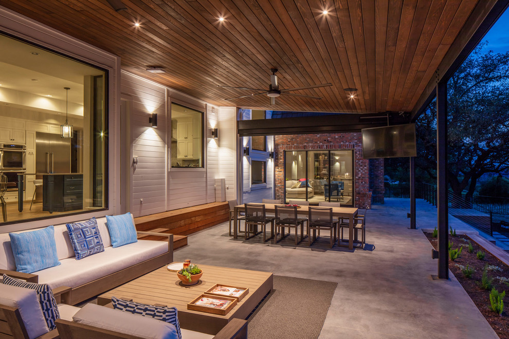 Inspiration for a large contemporary backyard verandah in Austin with concrete slab and an awning.