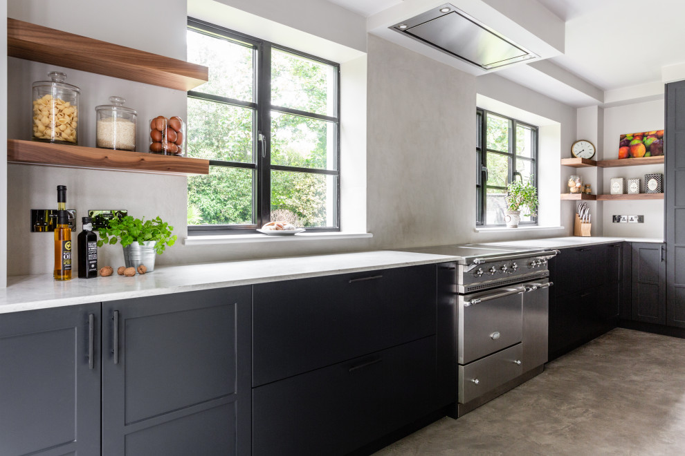 Large contemporary open plan kitchen in London with a drop-in sink, raised-panel cabinets, grey cabinets, quartz benchtops, white splashback, panelled appliances, with island and white benchtop.