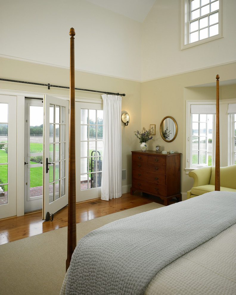 Photo of a large country master bedroom in Boston with beige walls and medium hardwood floors.