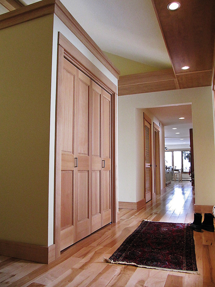 Hallway - mid-sized transitional light wood floor hallway idea with beige walls