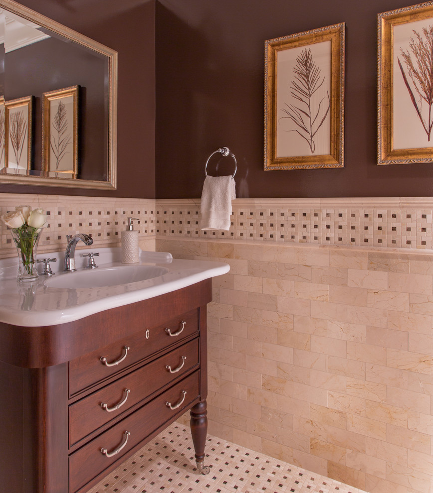 Design ideas for a mid-sized traditional 3/4 bathroom in Boston with furniture-like cabinets, dark wood cabinets, beige tile, travertine, brown walls, ceramic floors, an integrated sink, solid surface benchtops, multi-coloured floor and white benchtops.