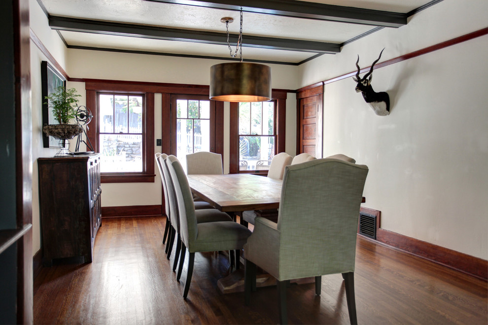 This is an example of a country dining room in Los Angeles with white walls and dark hardwood floors.