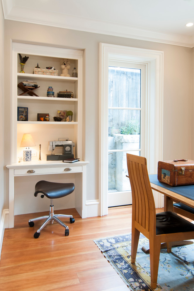 Inspiration for a mid-sized traditional craft room in San Francisco with beige walls, light hardwood floors, no fireplace and a built-in desk.