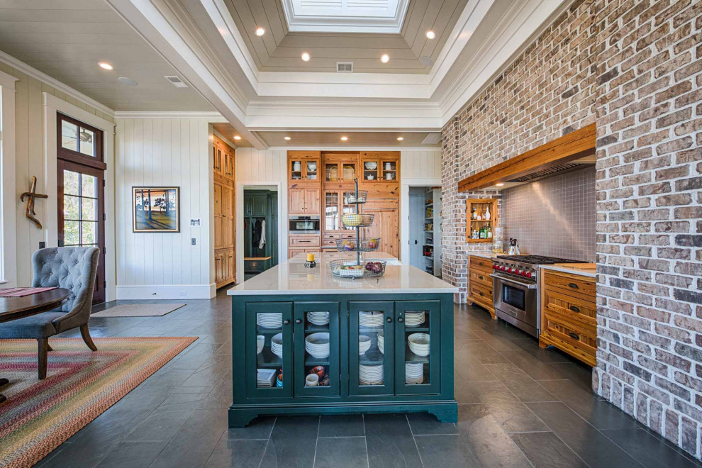 L-shaped slate floor, gray floor and tray ceiling eat-in kitchen photo with a farmhouse sink, recessed-panel cabinets, medium tone wood cabinets, gray backsplash, ceramic backsplash, an island and white countertops