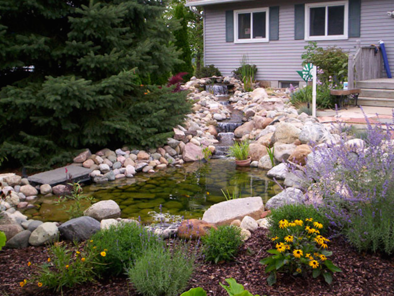 Design ideas for a large partial sun backyard water fountain landscape.
