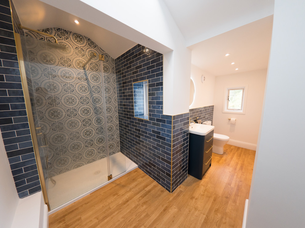 Esempio di una stanza da bagno con doccia minimal di medie dimensioni con consolle stile comò, ante blu, doccia aperta, piastrelle blu, piastrelle in ceramica, un lavabo e mobile bagno freestanding