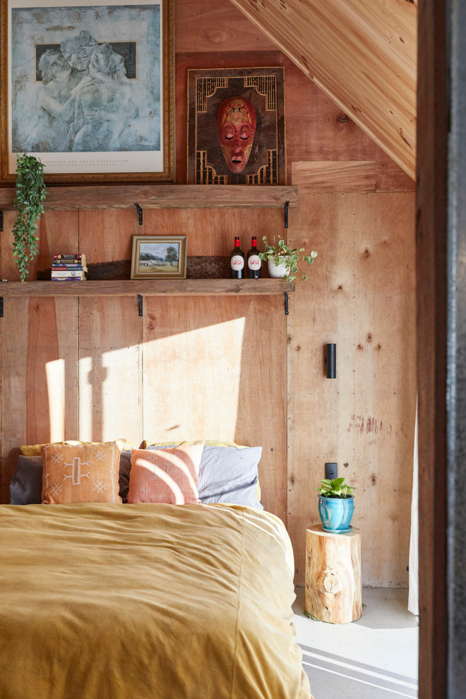 Idee per una camera da letto rustica con pavimento in cemento, soffitto a volta, soffitto in legno, pareti in legno, pareti marroni e pavimento grigio