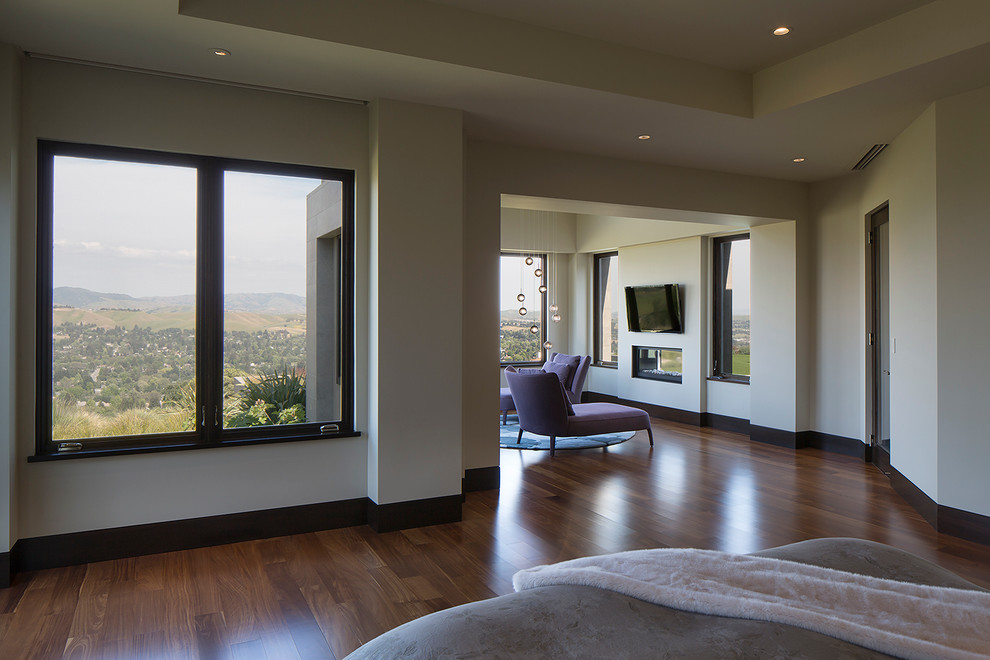 Inspiration for a modern master bedroom in San Francisco with white walls, medium hardwood floors and a ribbon fireplace.