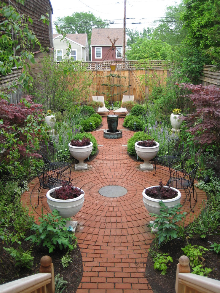 Mid-sized traditional backyard formal garden in New York with a water feature and brick pavers.