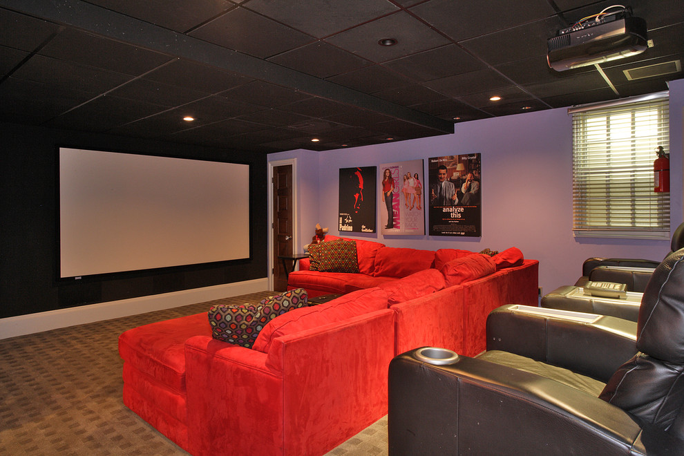 This is an example of a large eclectic enclosed home theatre in Newark with purple walls, carpet and a projector screen.