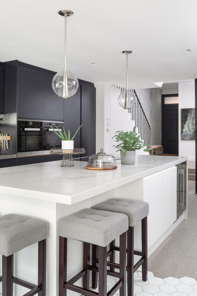 Design ideas for a large urban single-wall open plan kitchen in London with white cabinets and an island.