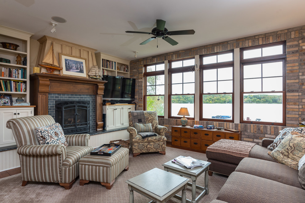 This is an example of a country family room in Minneapolis with a library, a standard fireplace, a tile fireplace surround and a freestanding tv.