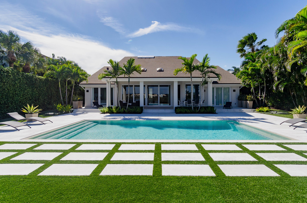Photo of a large tropical backyard full sun xeriscape in Miami with concrete pavers.