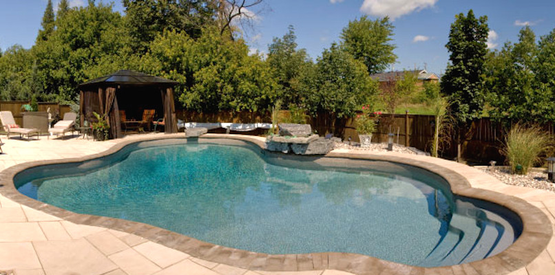 Inspiration for a mid-sized backyard concrete paver and freeform pool remodel