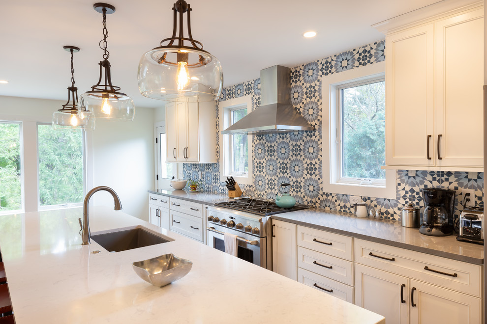 Inspiration for a mid-sized traditional galley eat-in kitchen in Detroit with a drop-in sink, quartzite benchtops, blue splashback, cement tile splashback, stainless steel appliances, dark hardwood floors, with island, brown floor and white benchtop.