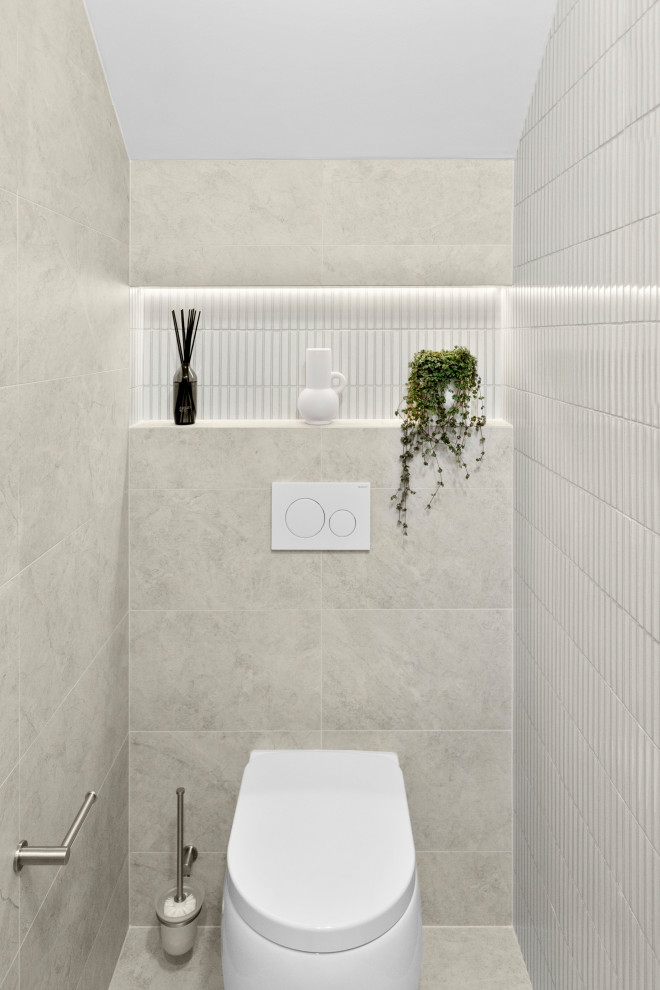 Photo of a small contemporary powder room in Sydney with furniture-like cabinets, medium wood cabinets, a one-piece toilet, multi-coloured tile, porcelain tile, multi-coloured walls, porcelain floors, a vessel sink, solid surface benchtops, multi-coloured floor, white benchtops and a floating vanity.