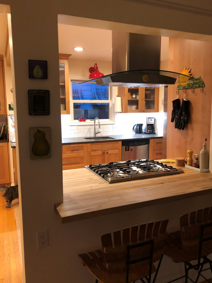 Eat-in kitchen - mid-sized transitional galley medium tone wood floor, brown floor and exposed beam eat-in kitchen idea in Seattle with an undermount sink, shaker cabinets, medium tone wood cabinets, quartz countertops, white backsplash, subway tile backsplash, stainless steel appliances, a peninsula and gray countertops