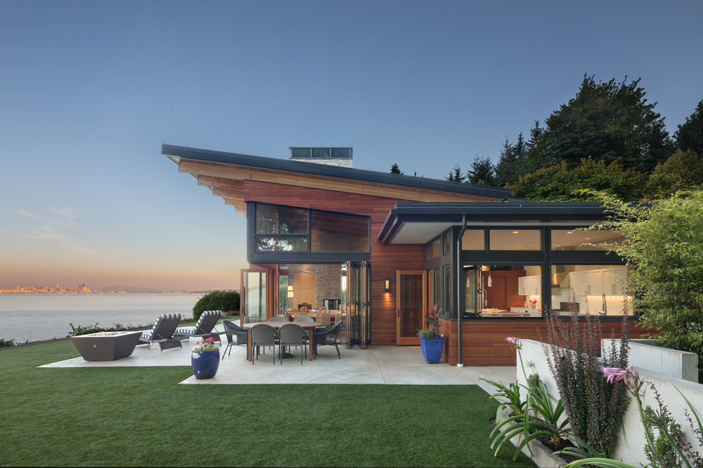 Inspiration for a mid-sized contemporary two-storey brown house exterior in Seattle with wood siding, a shed roof and a metal roof.