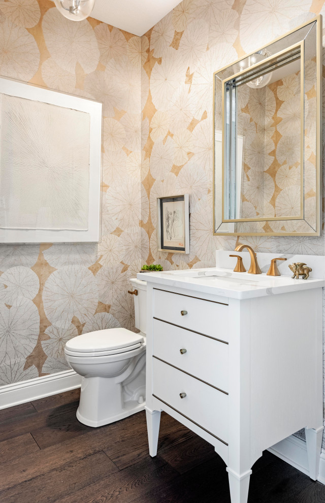 Photo of a transitional powder room in Tampa with flat-panel cabinets, white cabinets, a two-piece toilet, multi-coloured walls, medium hardwood floors, an undermount sink, brown floor, a freestanding vanity and wallpaper.