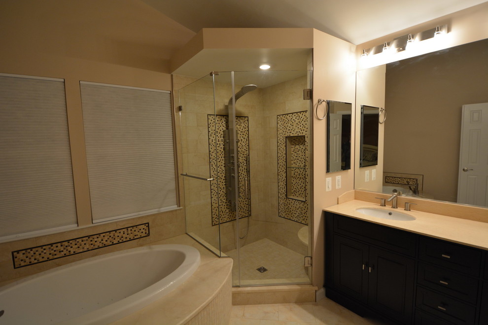 Drop-in bathtub - large transitional master beige tile and stone tile marble floor and beige floor drop-in bathtub idea in Baltimore with dark wood cabinets, a two-piece toilet, beige walls, an undermount sink, beaded inset cabinets, solid surface countertops, a hinged shower door and beige countertops