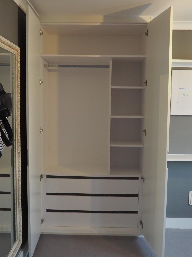 This is an example of a medium sized modern master bedroom in London with grey walls, carpet and beige floors.