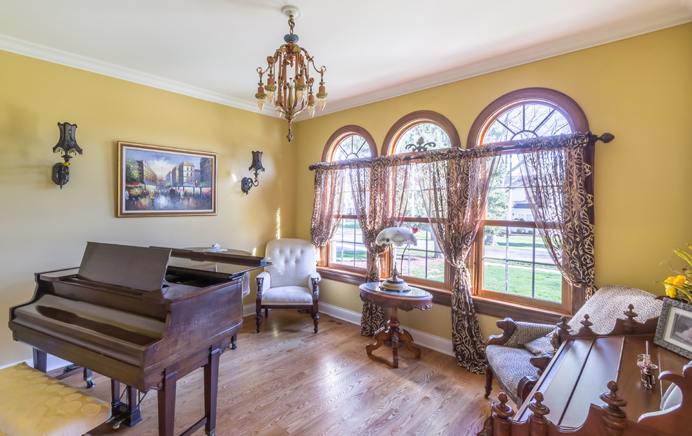 Mid-sized traditional enclosed living room in Chicago with a music area, yellow walls, medium hardwood floors, no tv, no fireplace, blue floor, wallpaper and wallpaper.