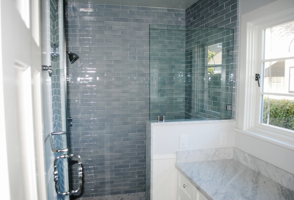 Traditional bathroom in Los Angeles with an undermount sink, recessed-panel cabinets, white cabinets, marble benchtops, an alcove shower, white tile and ceramic tile.