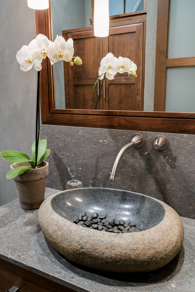 Large transitional powder room in Other with shaker cabinets, dark wood cabinets, a one-piece toilet, gray tile, stone tile, grey walls and a vessel sink.