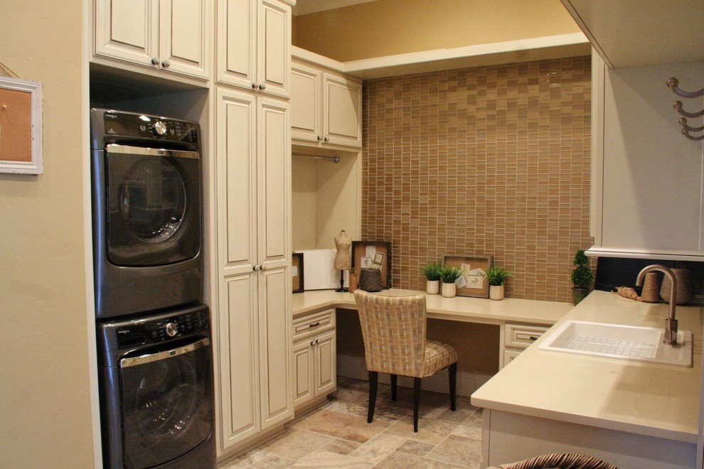 Photo of a traditional u-shaped laundry room in Seattle with a drop-in sink, raised-panel cabinets, beige cabinets, quartzite benchtops, beige walls, a stacked washer and dryer and beige benchtop.