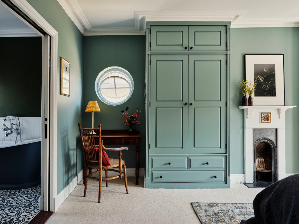 Inspiration pour une grande chambre traditionnelle avec un mur bleu, une cheminée standard, un manteau de cheminée en bois et un sol beige.