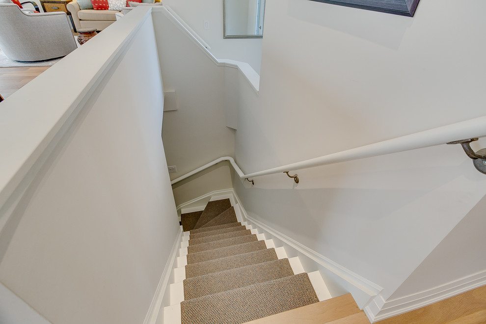 Inspiration for a mid-sized transitional carpeted curved staircase in Toronto with carpet risers and wood railing.
