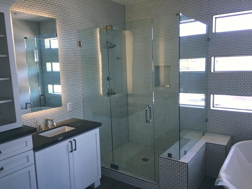 Photo of a transitional bathroom in Phoenix with shaker cabinets, white cabinets, a corner shower, white tile, subway tile, an undermount sink and a hinged shower door.