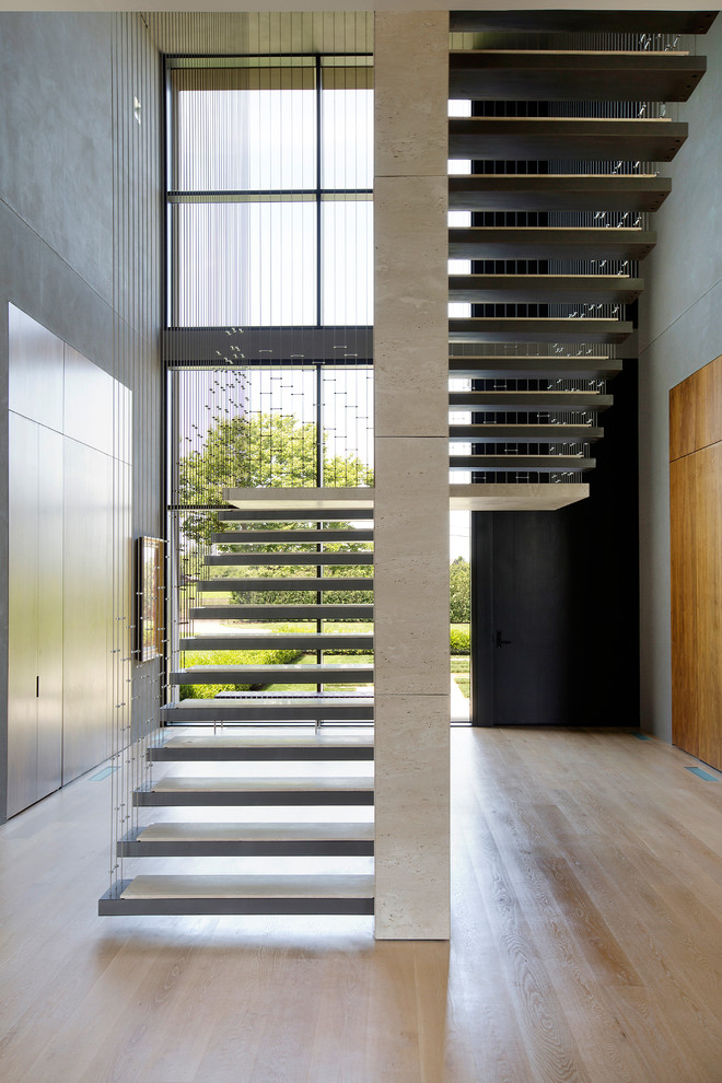 Design ideas for a contemporary u-shaped staircase in New York with open risers and cable railing.