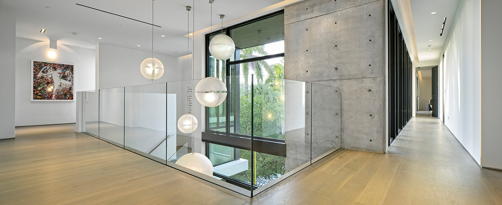 Expansive modern hallway in Miami with white walls, bamboo floors and beige floor.
