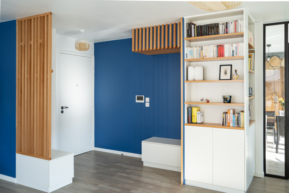 Idées déco pour un grand hall d'entrée contemporain avec un mur bleu, parquet foncé et une porte simple.
