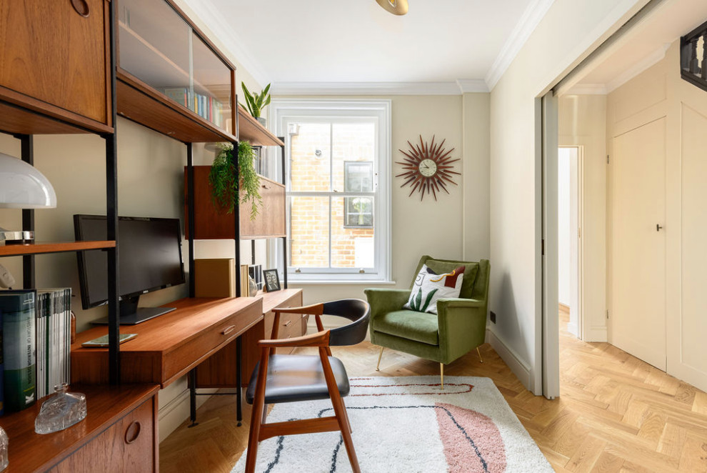 Foto di un ufficio moderno di medie dimensioni con pareti beige, pavimento in legno massello medio, nessun camino, scrivania autoportante e pavimento beige