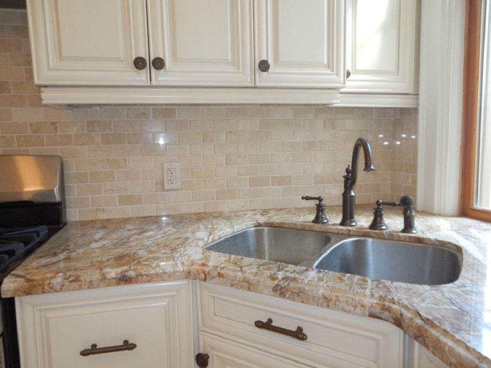Inspiration for a mid-sized transitional l-shaped ceramic tile eat-in kitchen remodel in Toronto with granite countertops, beige backsplash, stainless steel appliances, no island, a double-bowl sink, raised-panel cabinets and stone tile backsplash