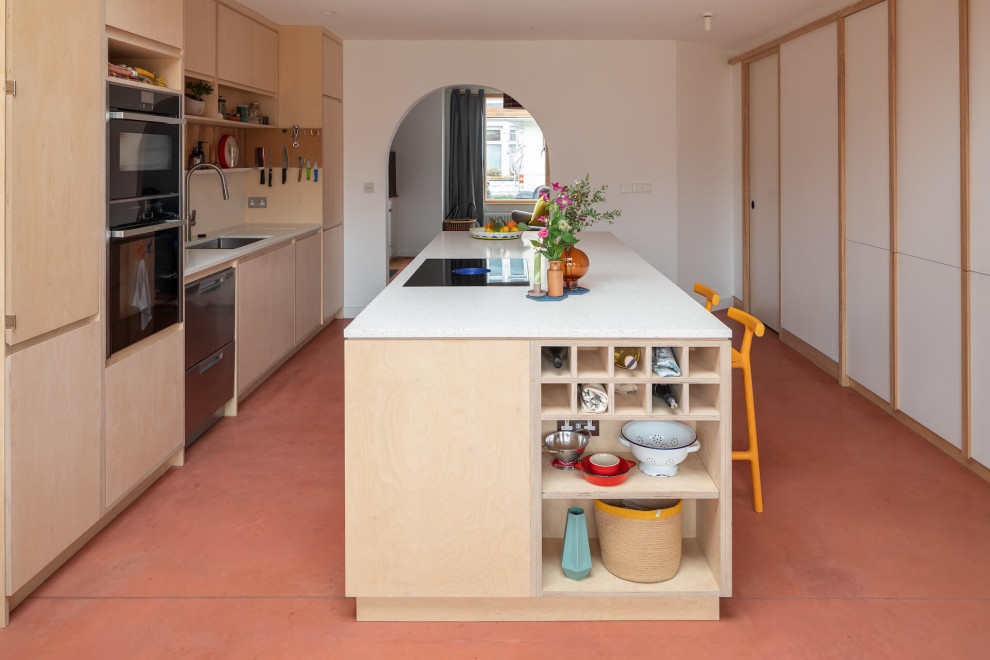 Offene, Zweizeilige, Große Moderne Küche mit flächenbündigen Schrankfronten, hellen Holzschränken, Betonboden, Kücheninsel und rosa Boden in Gloucestershire