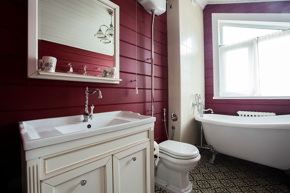 This is an example of a country master bathroom in Moscow with recessed-panel cabinets, white cabinets, a claw-foot tub, a shower/bathtub combo, a two-piece toilet, red walls and an integrated sink.