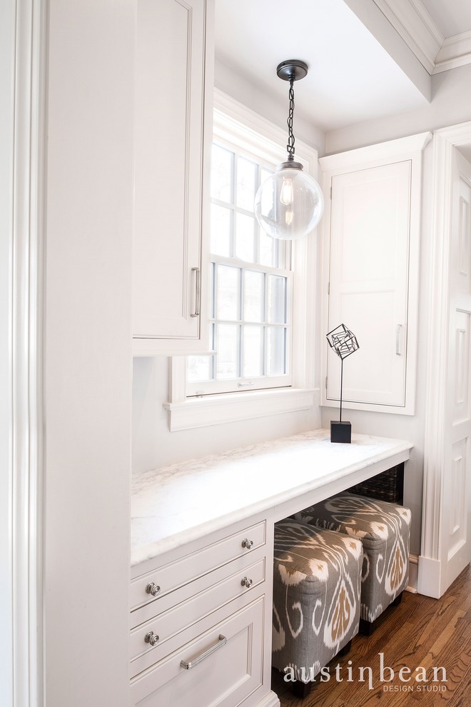 Example of a transitional l-shaped medium tone wood floor eat-in kitchen design with a farmhouse sink, beaded inset cabinets, white cabinets, marble countertops, white backsplash, subway tile backsplash, stainless steel appliances, gray walls and an island