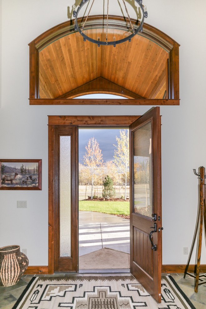 Front door - large rustic slate floor and multicolored floor front door idea with white walls and a dark wood front door
