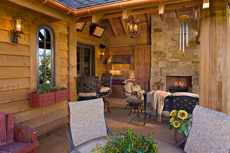 Inspiration for a rustic stamped concrete patio remodel with a fire pit and a roof extension